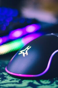 A close-up of a colorful gaming mouse and illuminated RGB keyboard, perfect for tech setups.